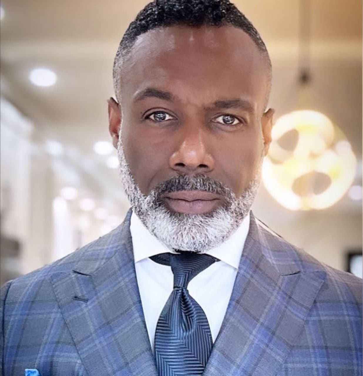 Senior African-American man in a professional suit and tie, looking confidently into the camera.